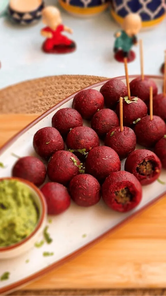 Deep ruby-red spicy beetroot thecha pops arranged on wooden board with peanuts