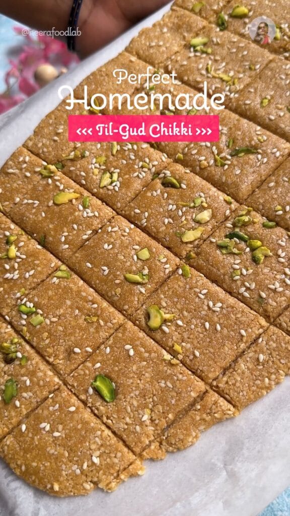 Square pieces of soft Til Gud Chikki (Sesame Jaggery Brittle) garnished with chopped cashew and sesame seeds