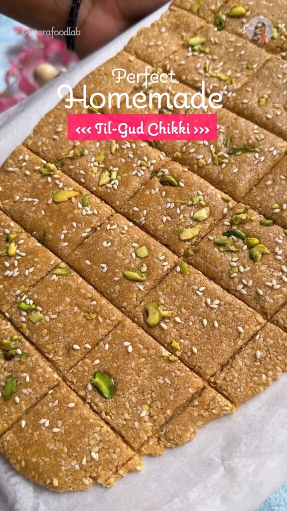 Square pieces of soft Til Gud Chikki (Sesame Jaggery Brittle) garnished with chopped cashew and sesame seeds